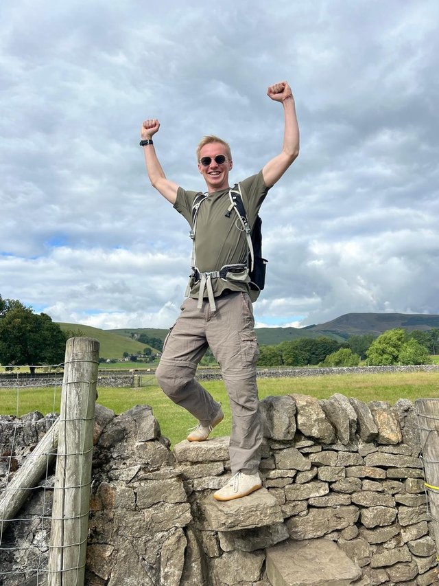 Max on a countryside walk, arms raised in celebration